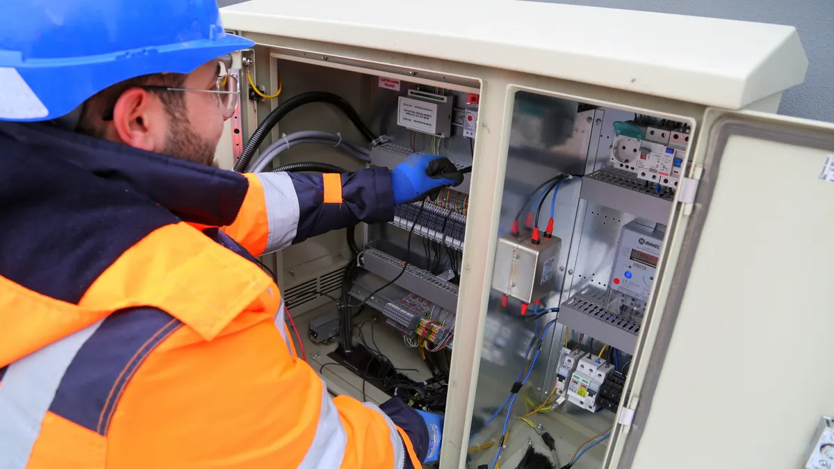 Electrical panel upgrades and breakers — The Complete Guide Worker servicing an open electrical cabinet