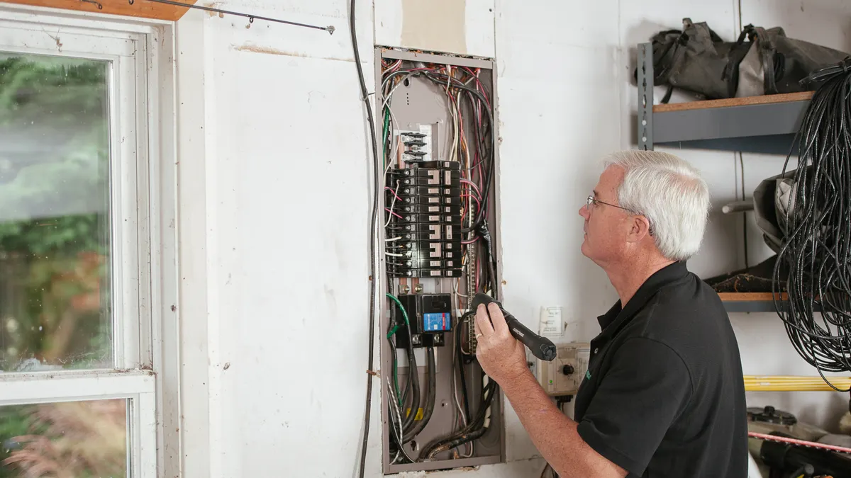 Man inspecting an open home electrical panel