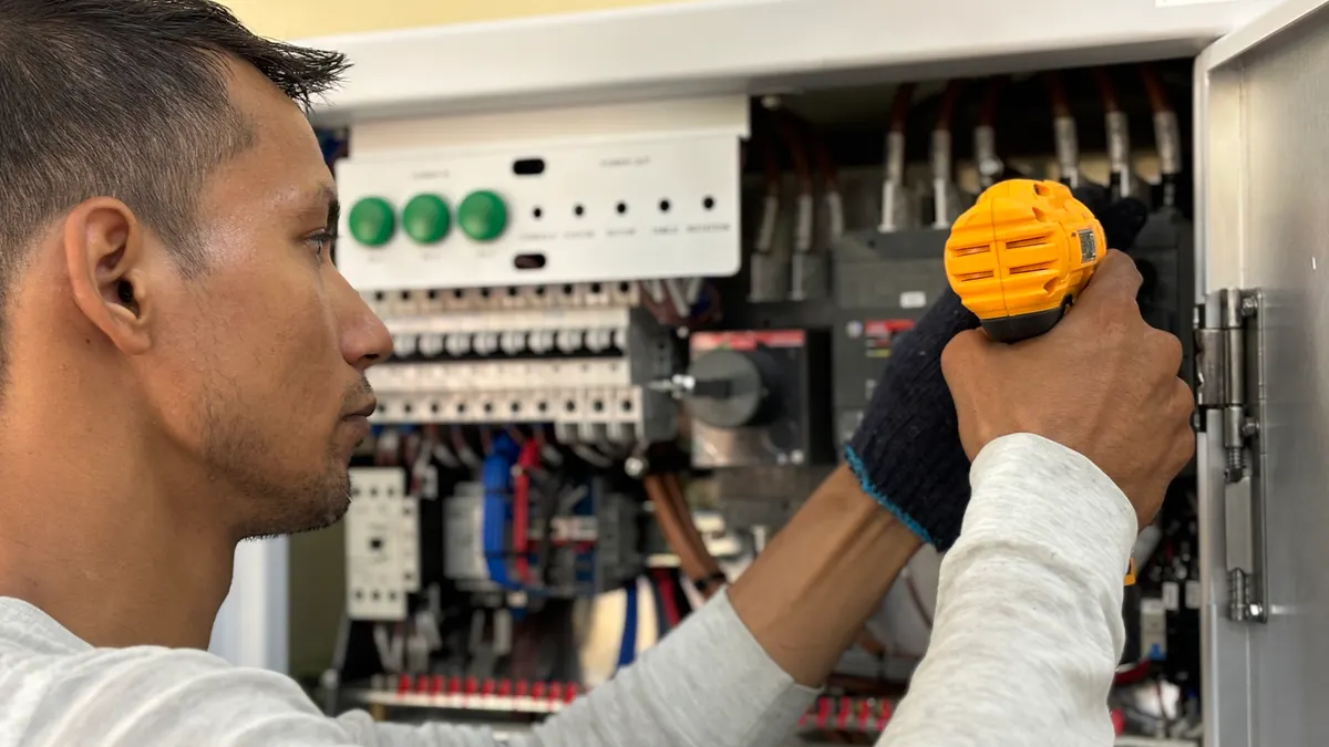 Home electrical safety basics: what every homeowner should know Worker using a drill on an open electrical panel