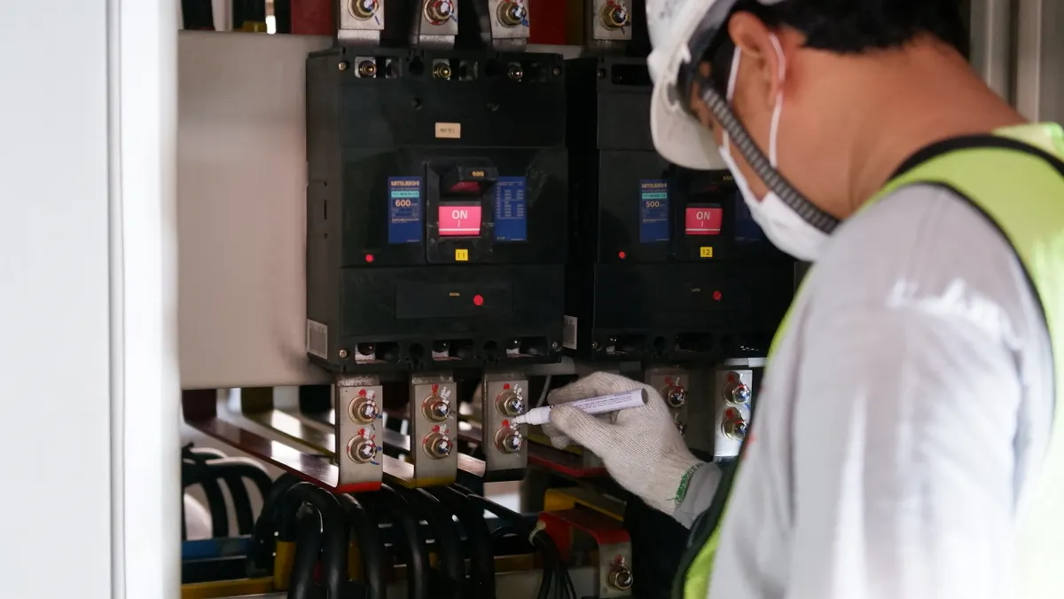 Electrician inspecting an open breaker panel